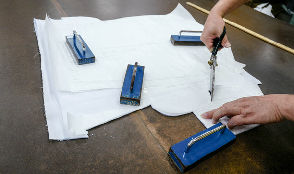 Tailor cutting fabric with a pattern for garment making